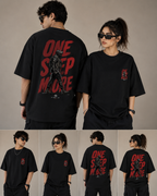 A collage showing a model from the front and back wearing an oversized black graphic T-shirt. The front view shows a small red and black graphic on the left chest, and the back view shows large distressed red text reading 'ONE STEP MORE' with a black illustrated figure.