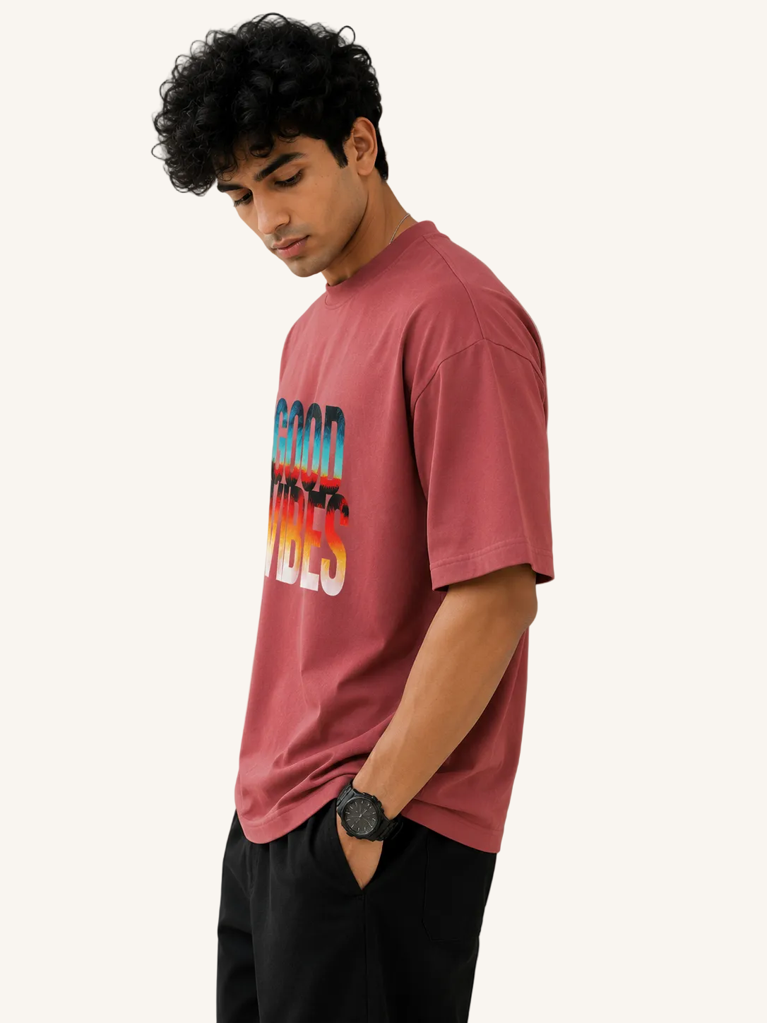 Man wearing a red t-shirt with colorful text against a beige background