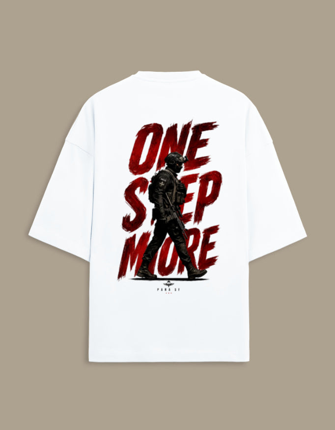 A white oversized short-sleeve t-shirt with a large graphic print on the back. The graphic features the text 'ONE STEP MORE' in a distressed red brush font, overlaid with a black silhouette of a soldier in tactical gear.