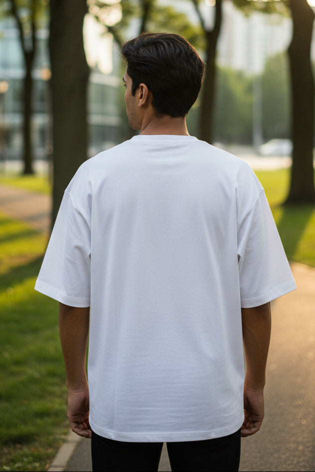 A plain white short-sleeve t-shirt shown from the back, laid flat against a light cream background.
