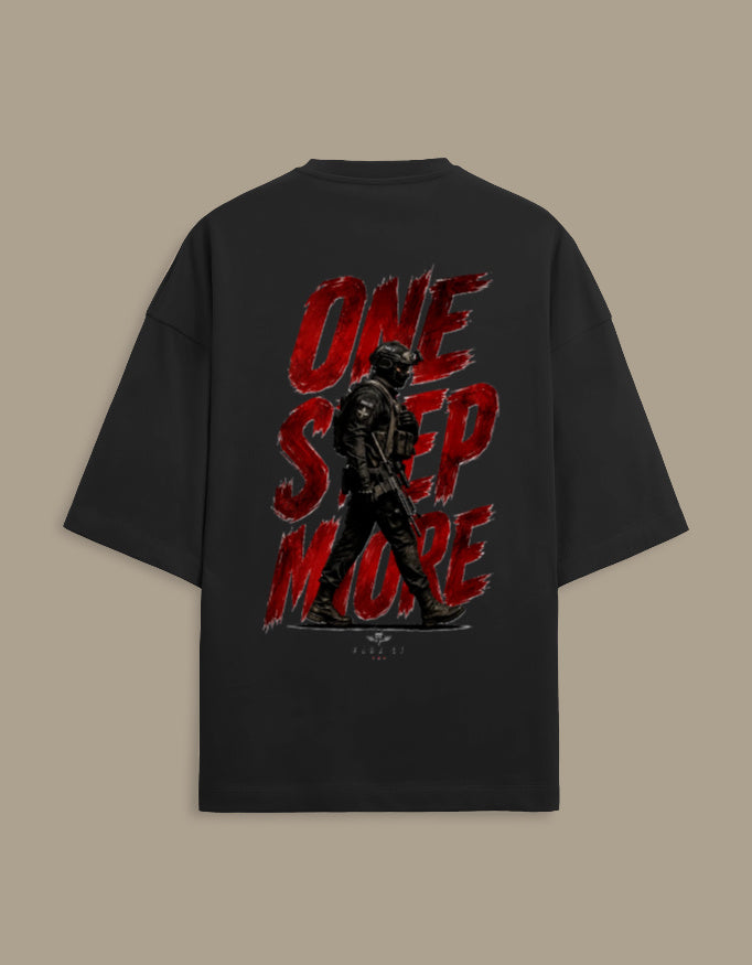 A black oversized t-shirt shown from the back, featuring a large graphic print with the words 'ONE STEP MORE' in distressed red lettering and a dark soldier silhouette.