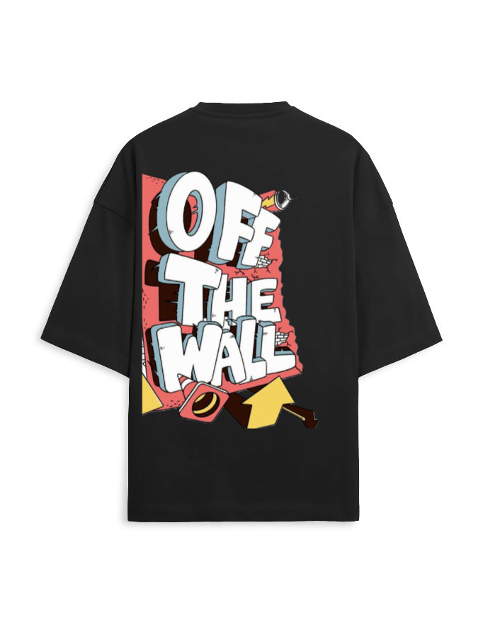 A black oversized short-sleeve t-shirt with a large graphic print on the back. The graphic features the text 'OFF THE WALL' in bold white 3D letters with gray shadows, set against a red and yellow comic-style background.