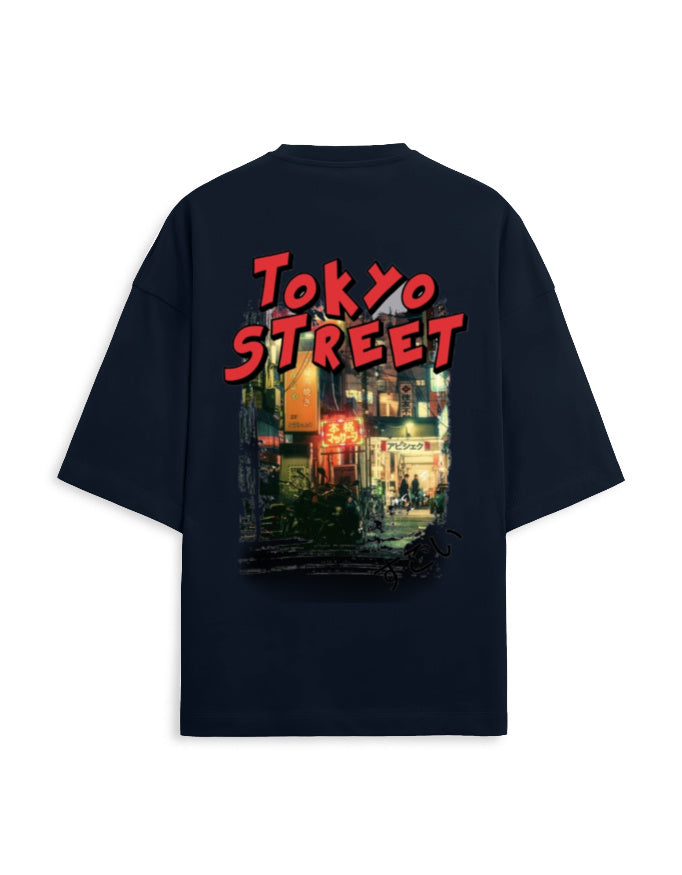 A black oversized short-sleeve t-shirt shown from the back, featuring a large graphic print with the words 'TOKYO STREET' in red and a colorful neon-lit city scene.