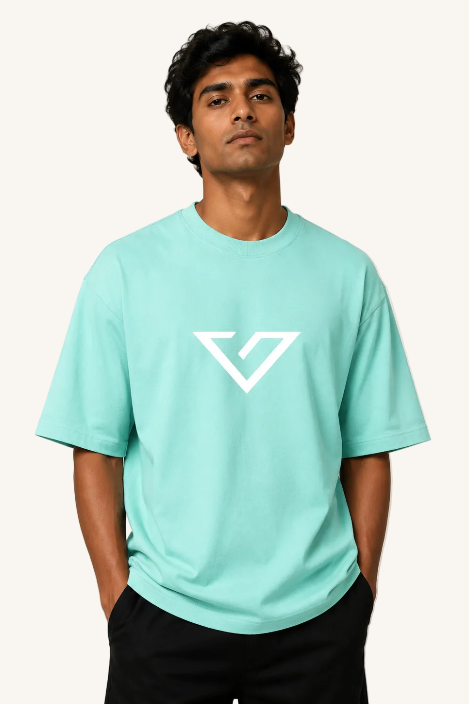 Man wearing a light blue t-shirt with a logo on a beige background