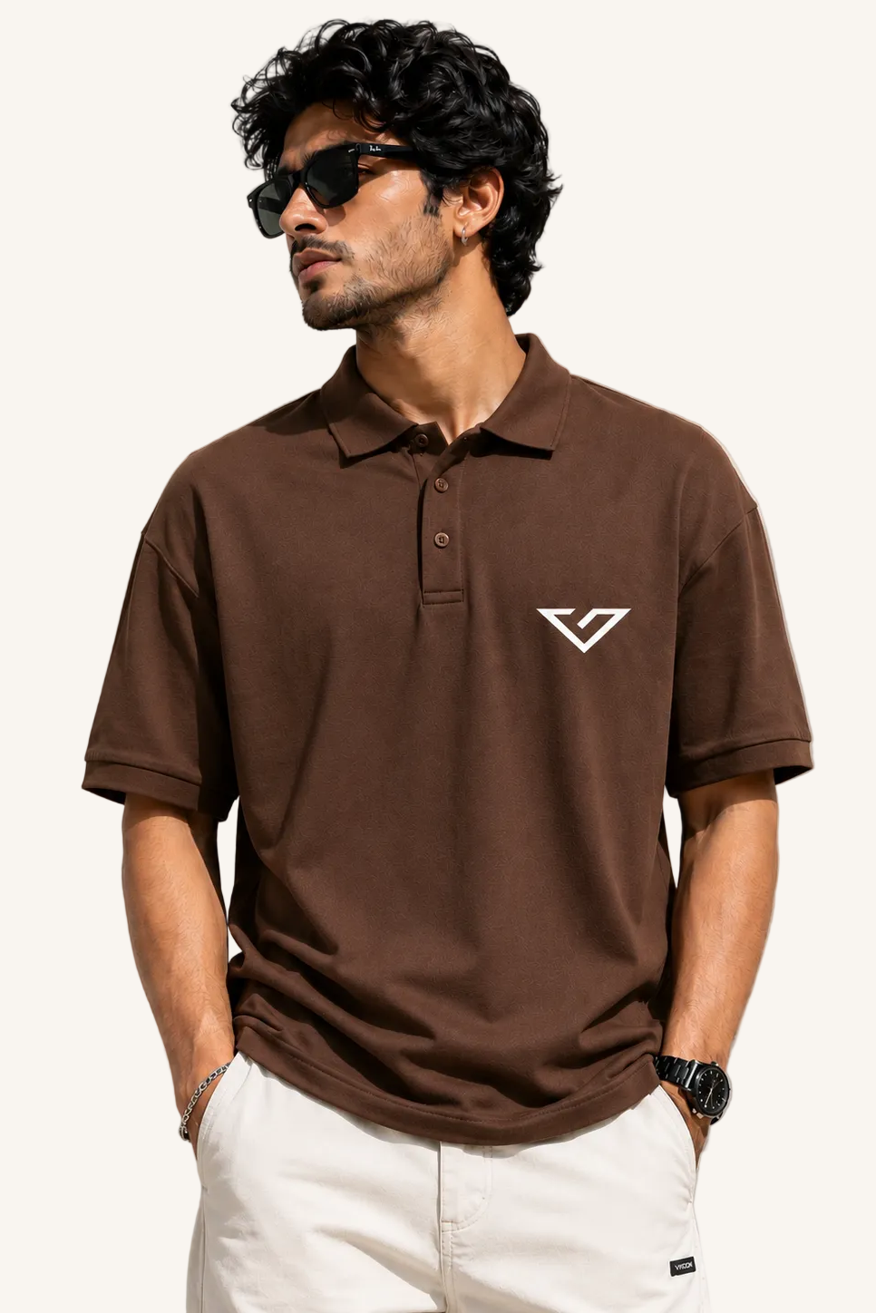 Man wearing a brown polo shirt with a logo on a beige background