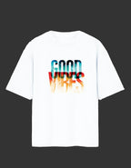 A white short-sleeve crewneck t-shirt featuring a colorful graphic print on the chest that reads 'GOOD VIBES' in a watercolor-style gradient of blue, red, and orange.