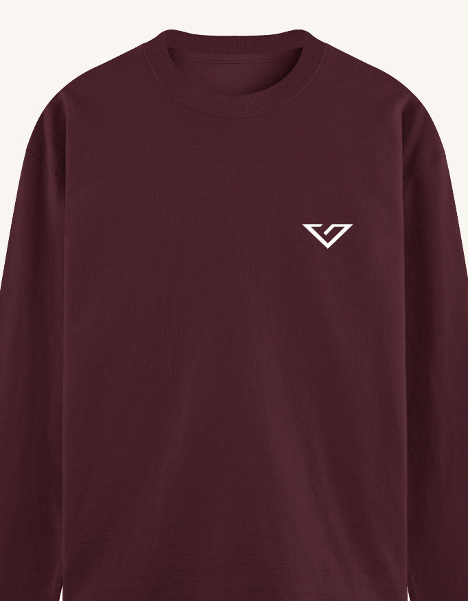 A close-up of a crewneck sweatshirt in deep burgundy with a small white stylized 'V' logo on the left chest, set against a light off-white background.
