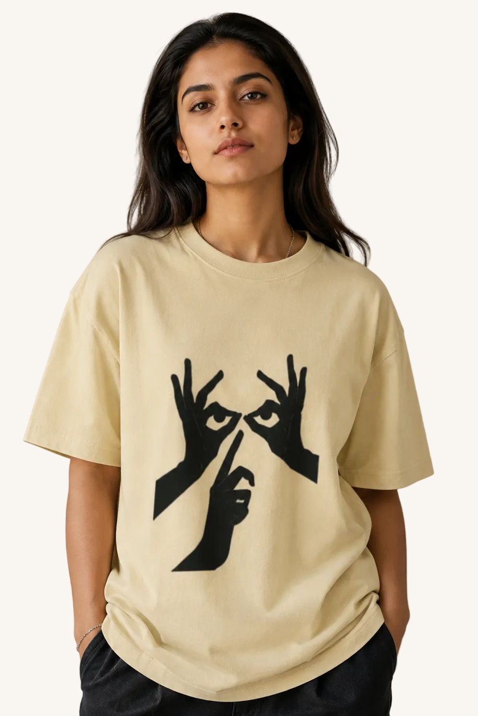 Person wearing a beige t-shirt with black graphic design on a neutral background