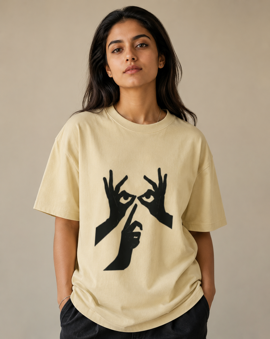 Person wearing a beige t-shirt with black graphic design on a neutral background