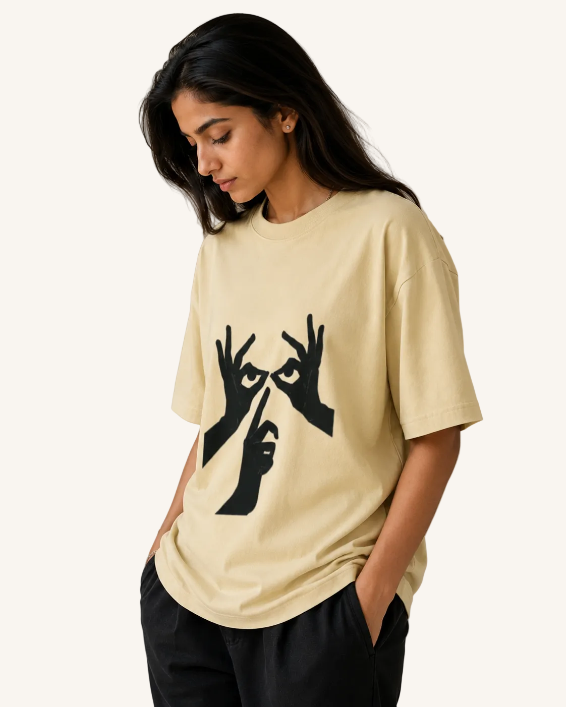 Woman wearing a beige t-shirt with black graphic design on a neutral background