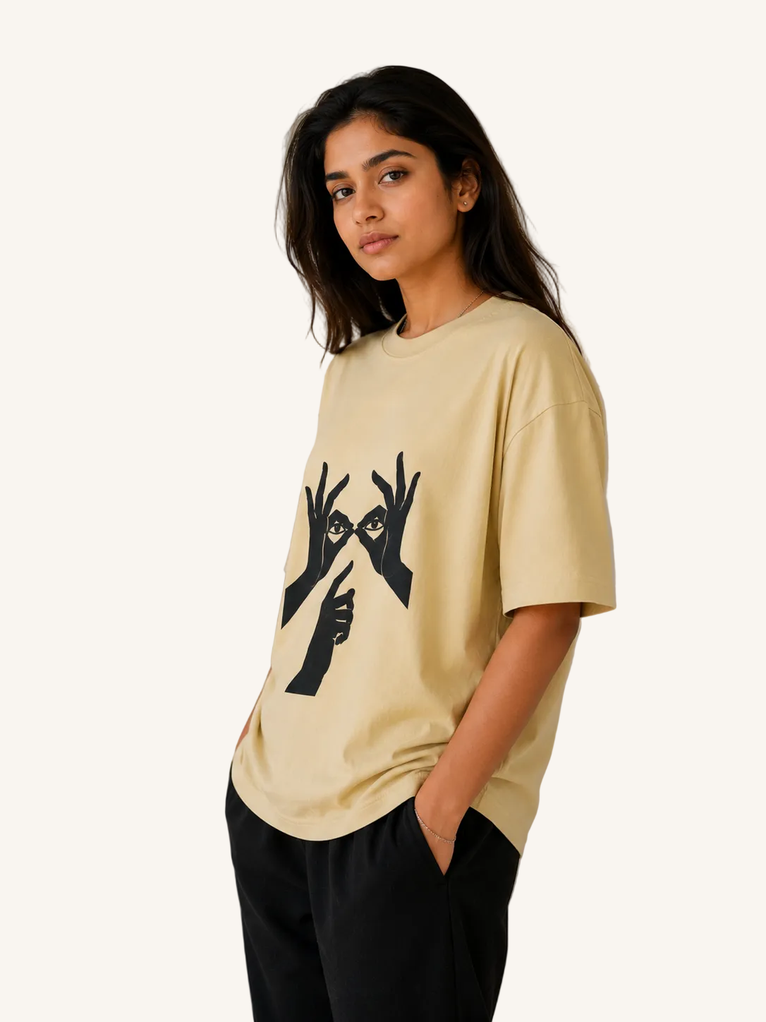 A woman wearing a light yellow t-shirt with black graphic design on a beige background