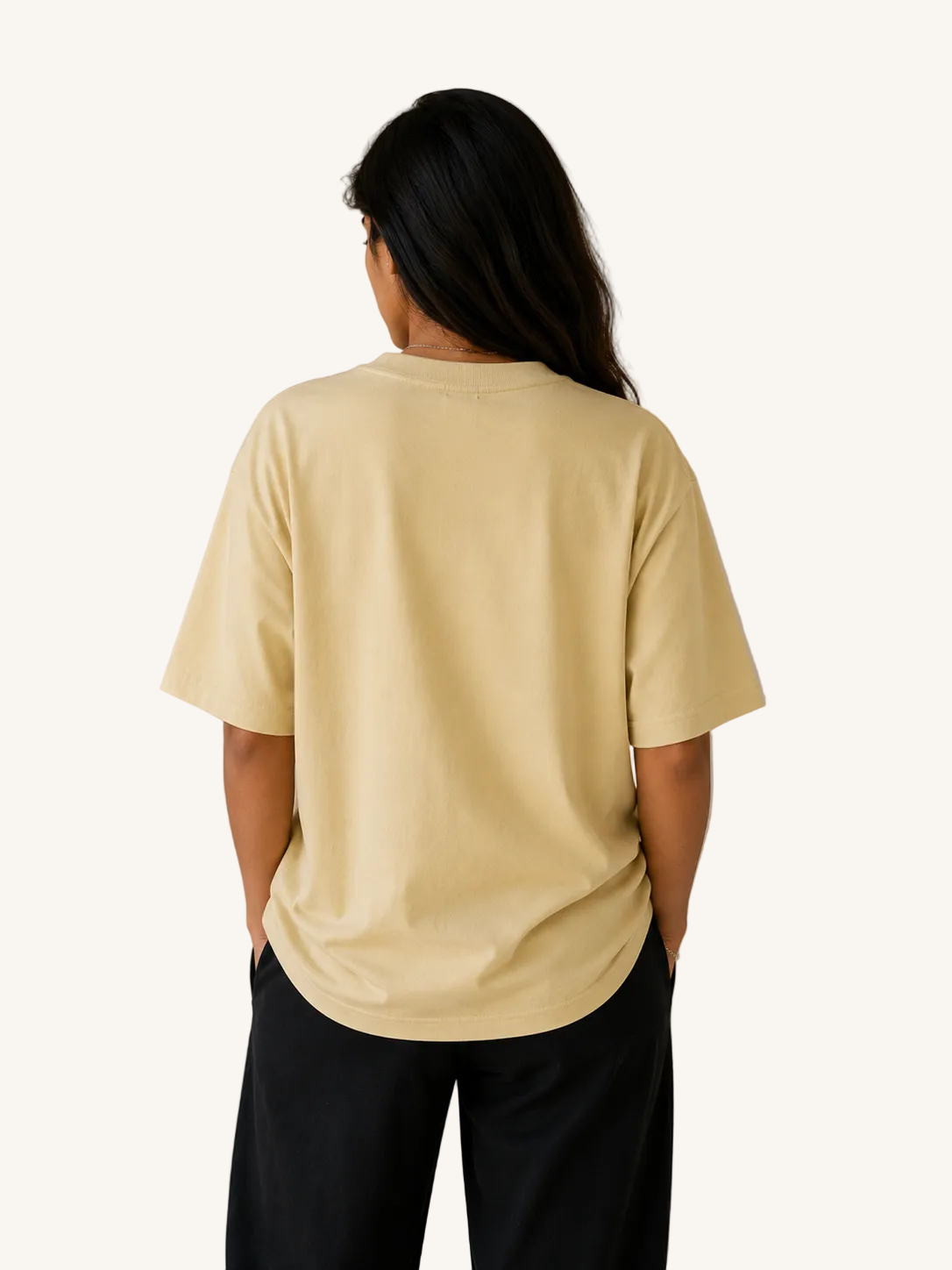 Person wearing a beige t-shirt and black pants against a beige background