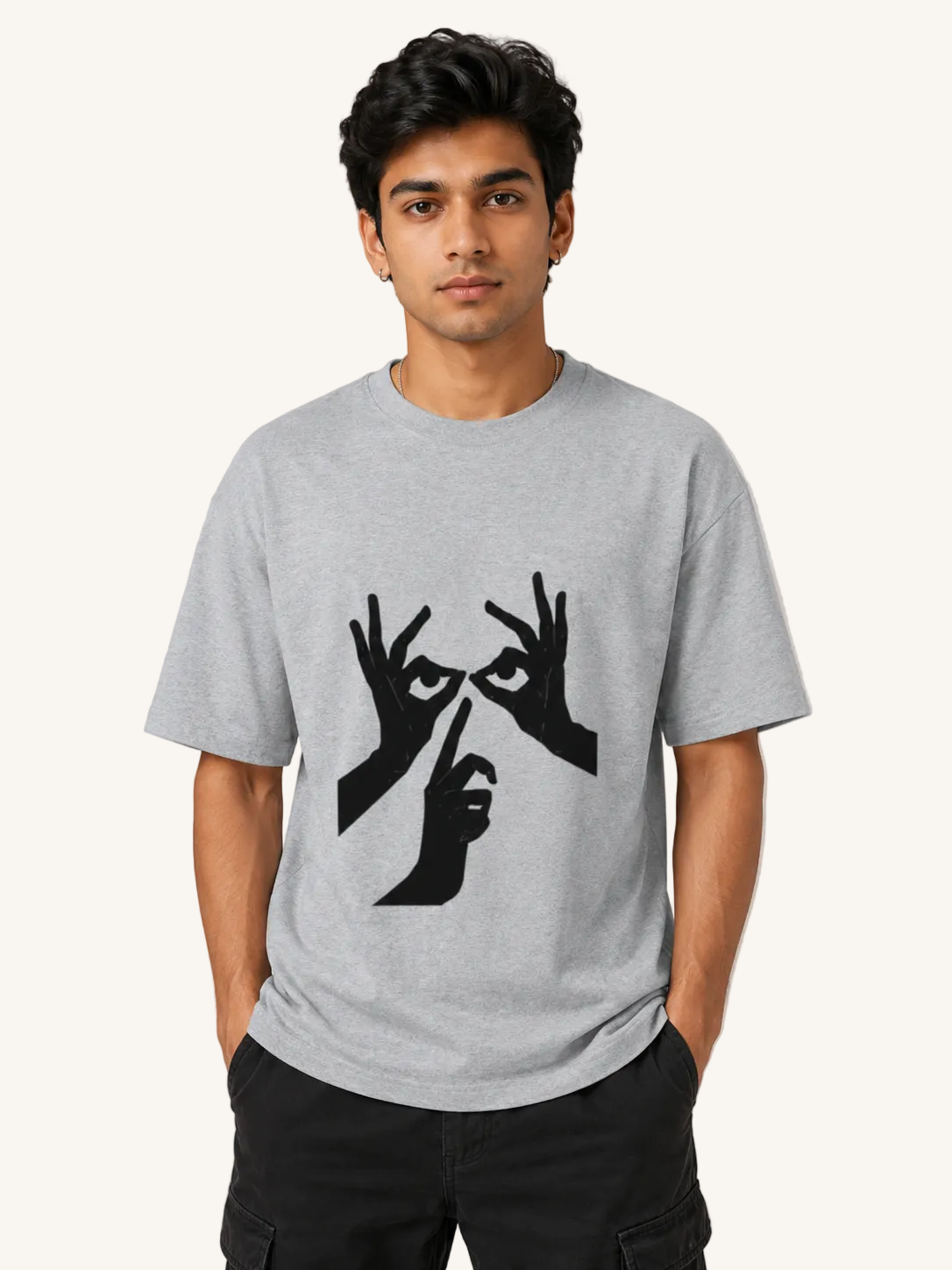 Person wearing a gray t-shirt with a black graphic design on a plain background