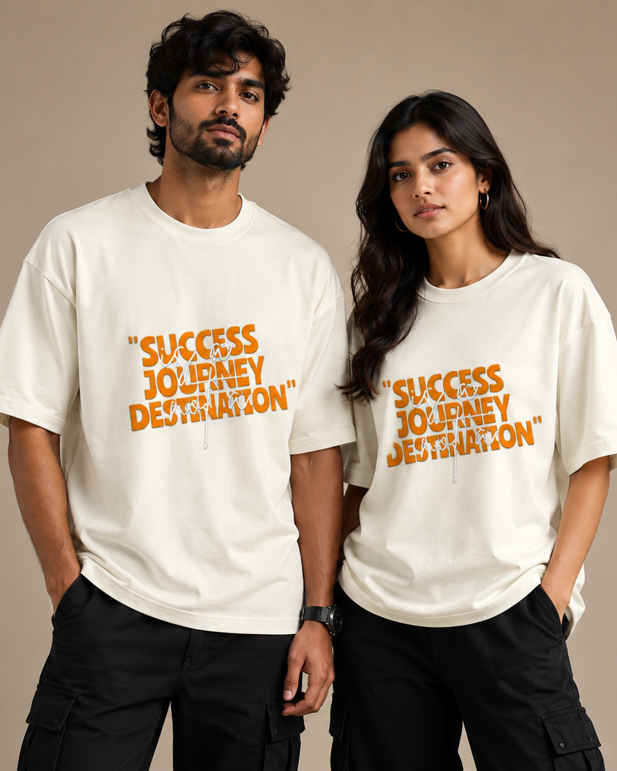 A man and a woman modeling matching white oversized T-shirts with orange text that reads “SUCCESS IS A JOURNEY DESTINATION,” posed against a plain beige studio background.