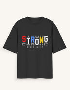 A black short-sleeve t-shirt with a graphic on the chest spelling 'STRONG' in red, blue, yellow, and white, with 'NEVER GIVE UP' printed below it, shown against a light off-white background.