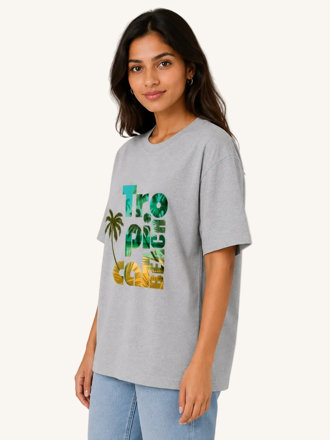 Woman wearing a gray t-shirt with 'Tropical Beach' text and palm tree design on a beige background