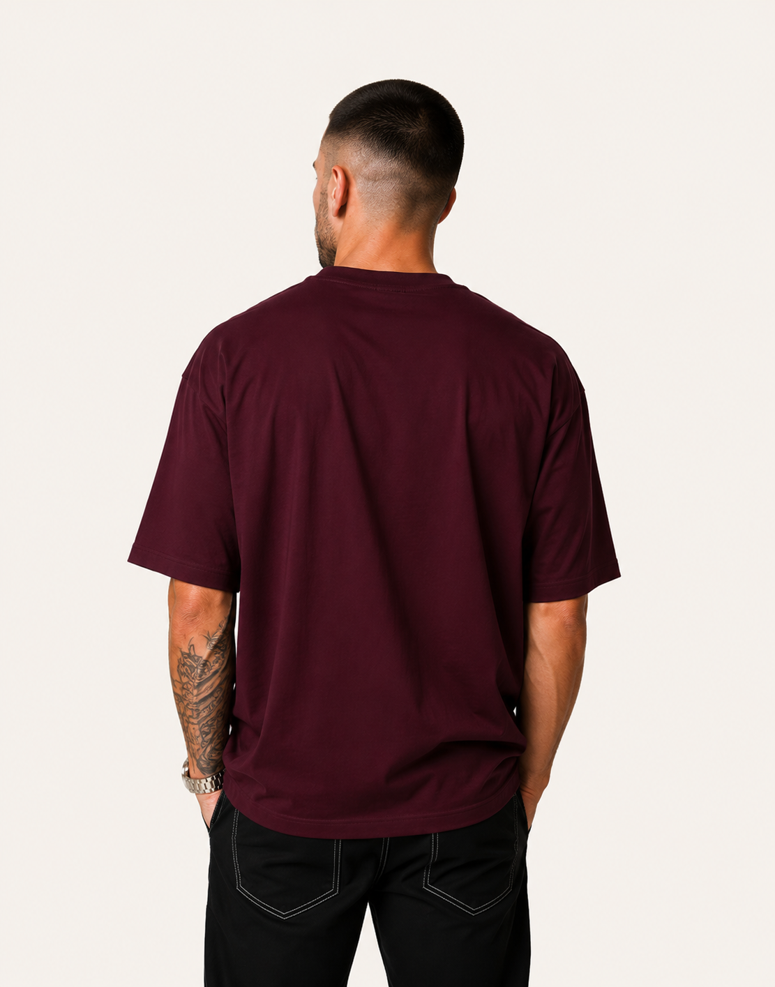 Man wearing a maroon t-shirt on a plain background