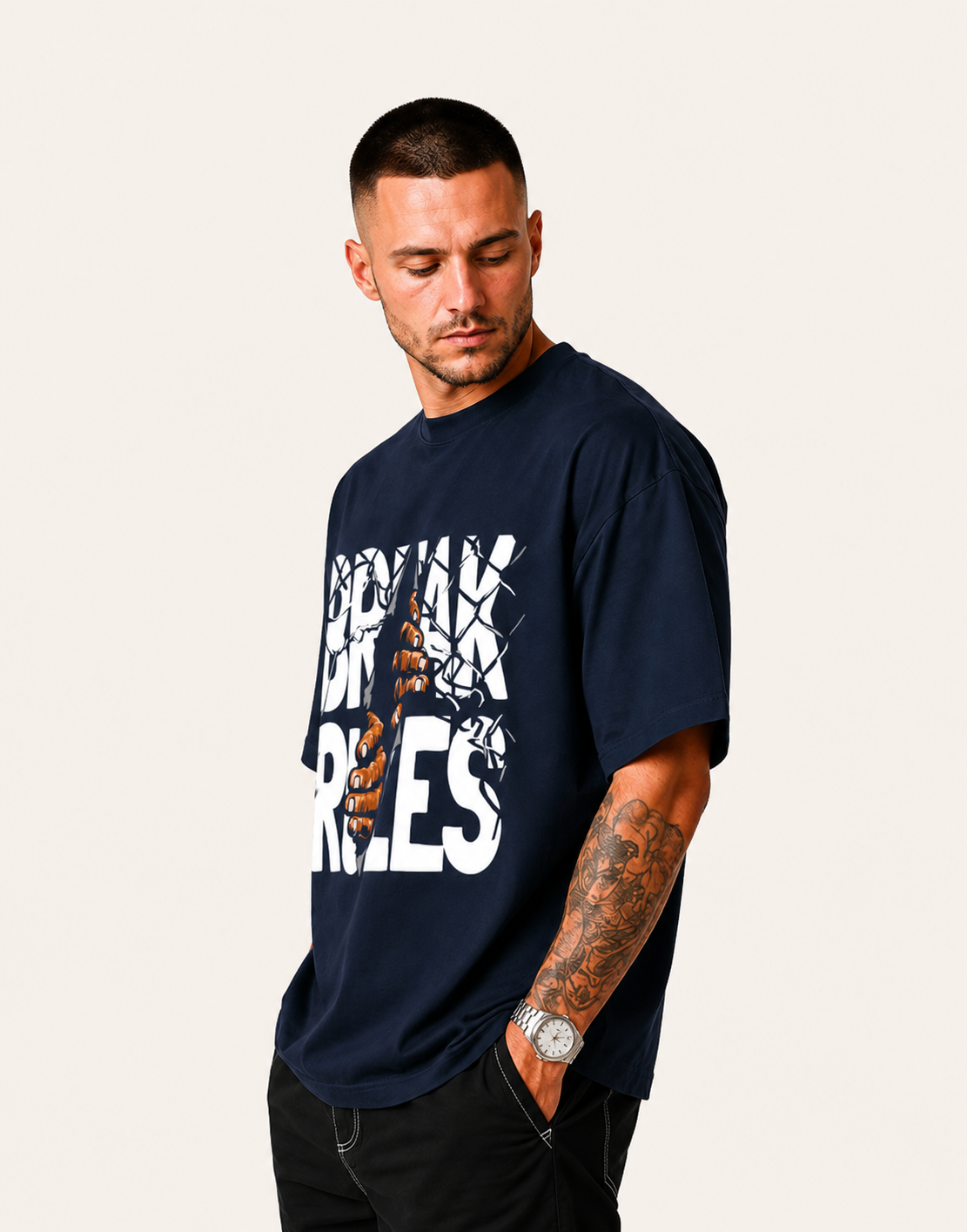 Man wearing a navy blue t-shirt with a graphic design on a plain background