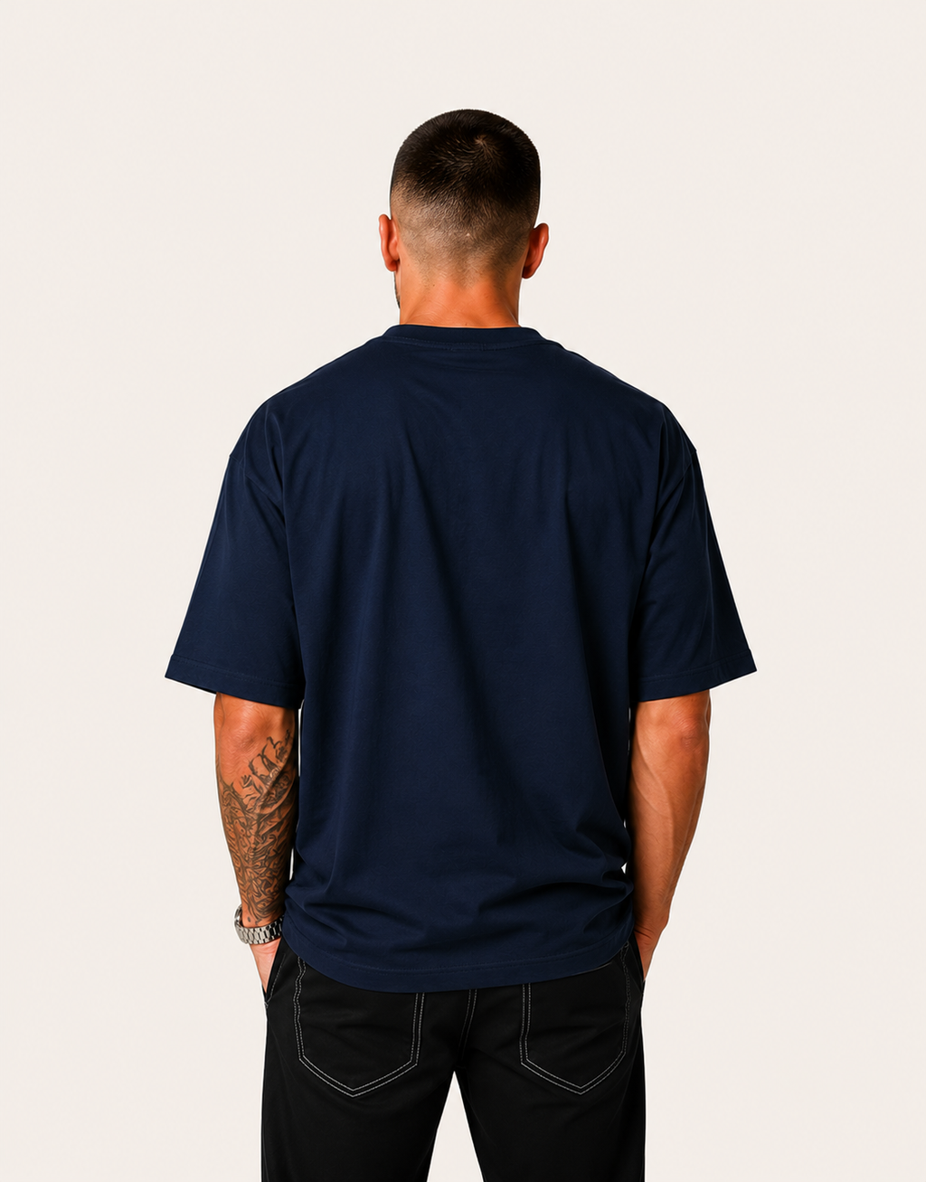 Man wearing a navy blue t-shirt on a plain background