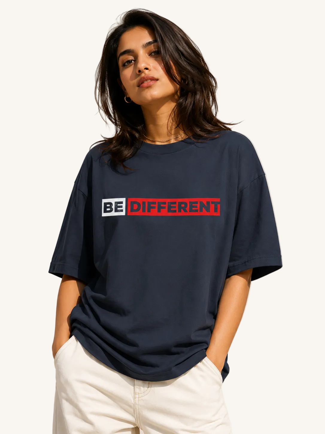 Woman wearing a navy blue t-shirt with 'BE DIFFERENT' text on a beige background