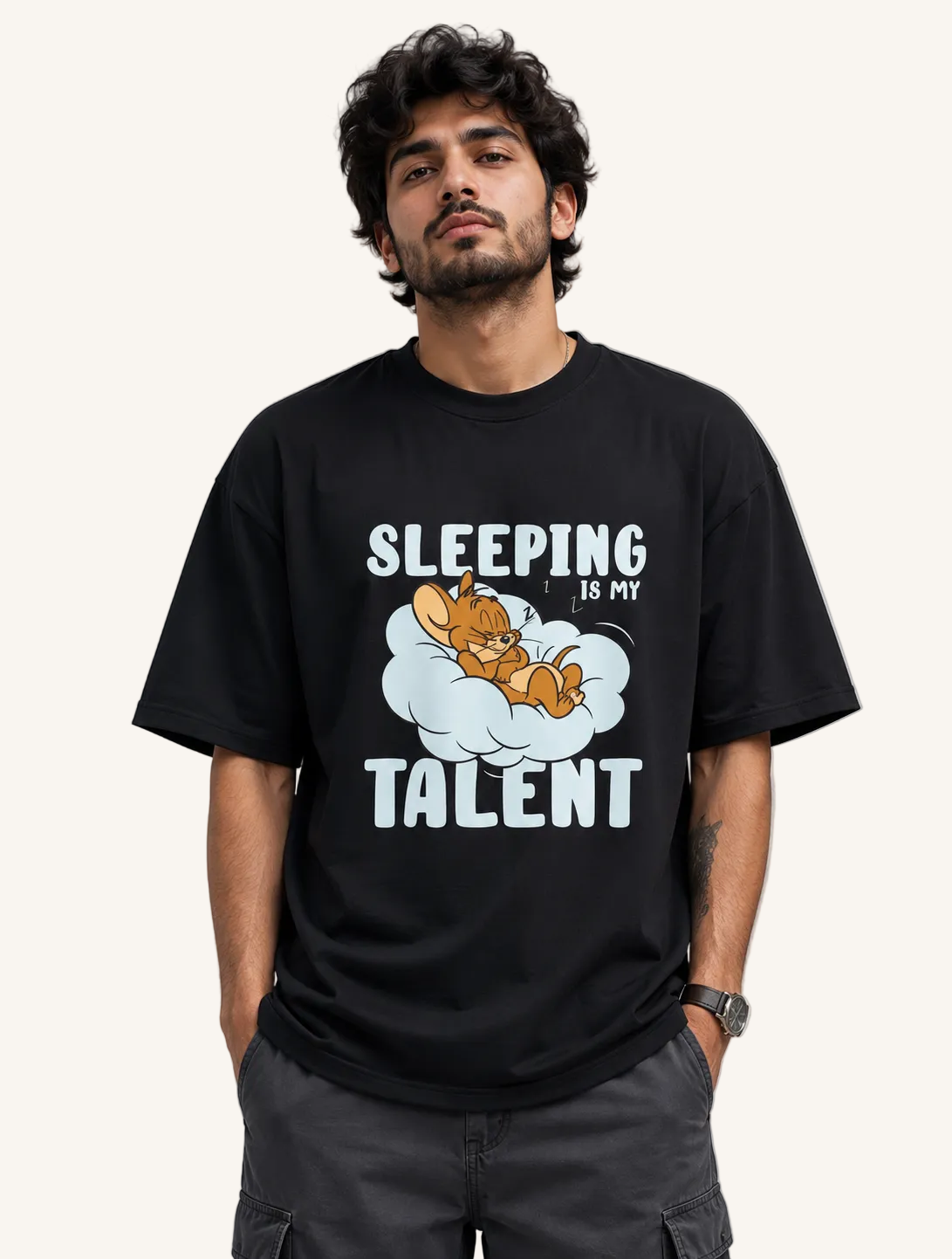 Person wearing a black t-shirt with a graphic of a cat sleeping and text 'Sleeping is my talent' on a gray background