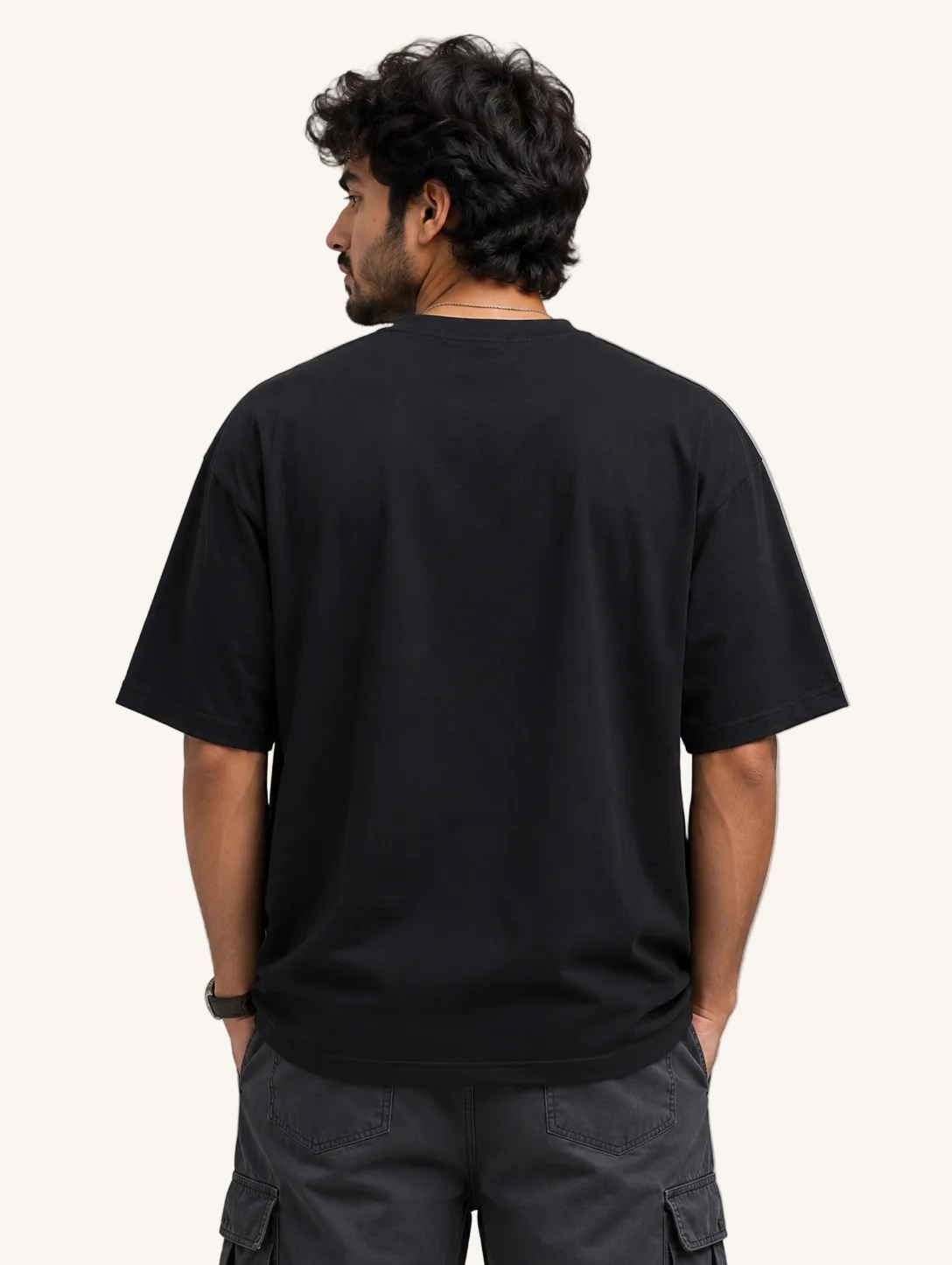 Person wearing a black t-shirt on a gray background