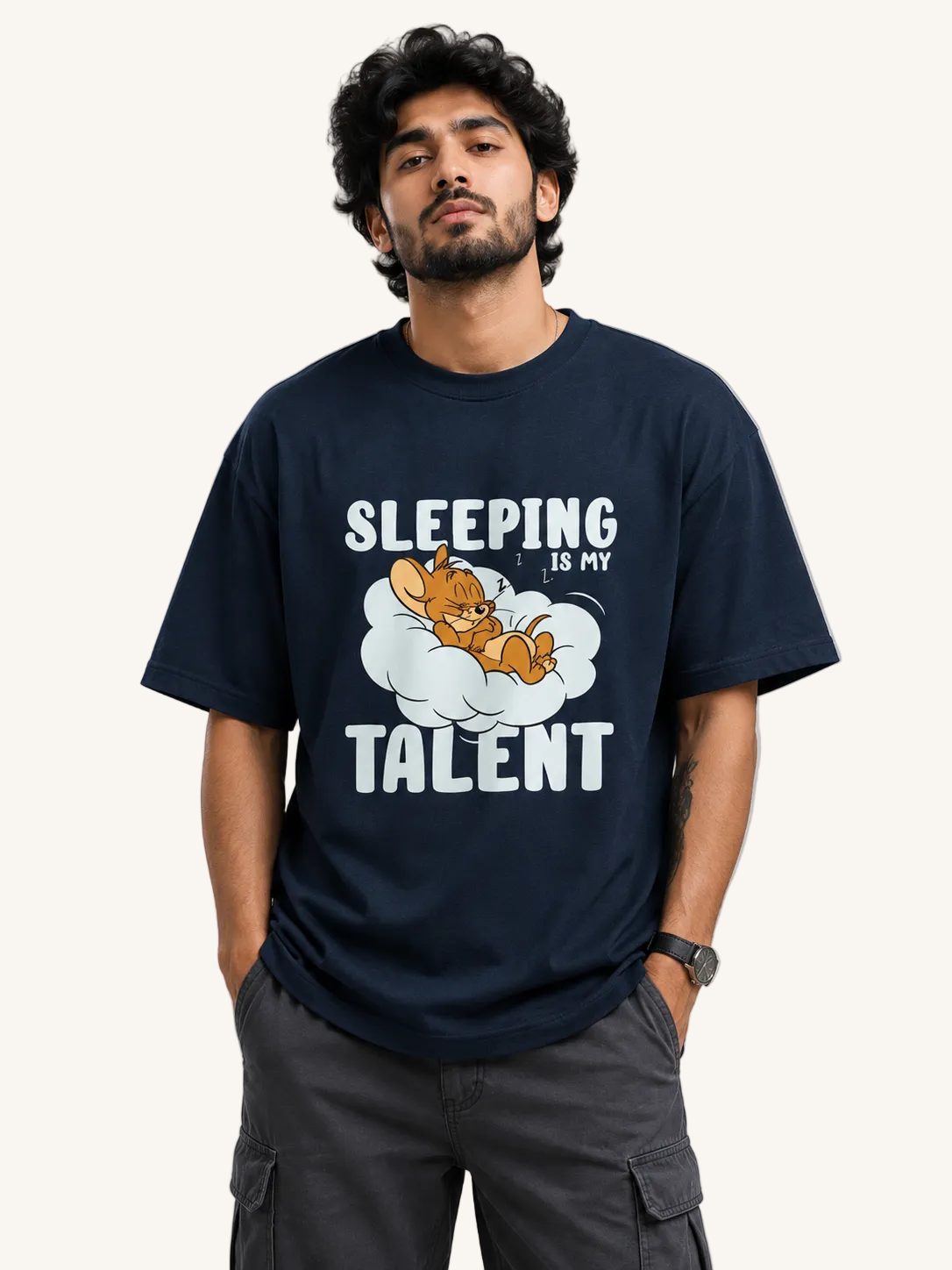 Person wearing a navy blue t-shirt with a graphic and text 'Sleeping is my talent' on a gray background