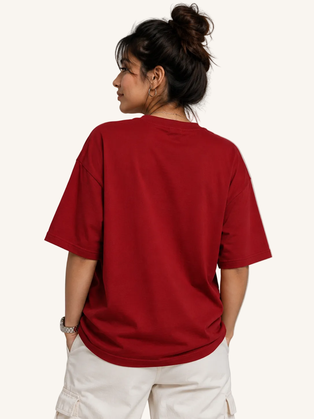 Person wearing a red t-shirt and white pants against a gray background