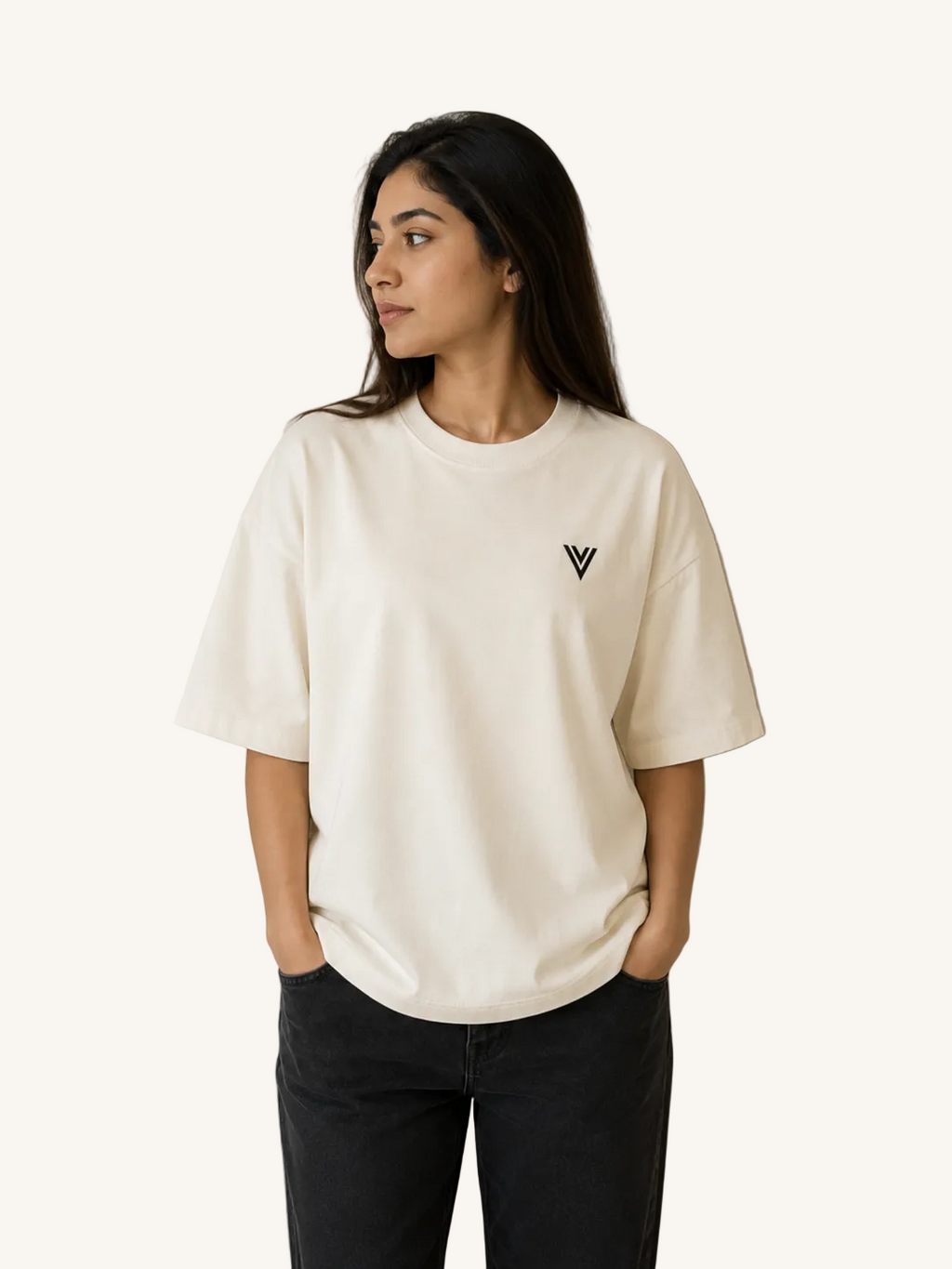 Woman wearing a white t-shirt with a black logo against a plain background